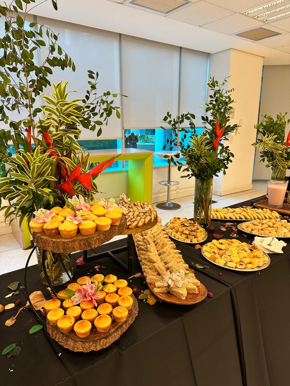 Mesa de coffee break com doces, biscoitos e mini bolos