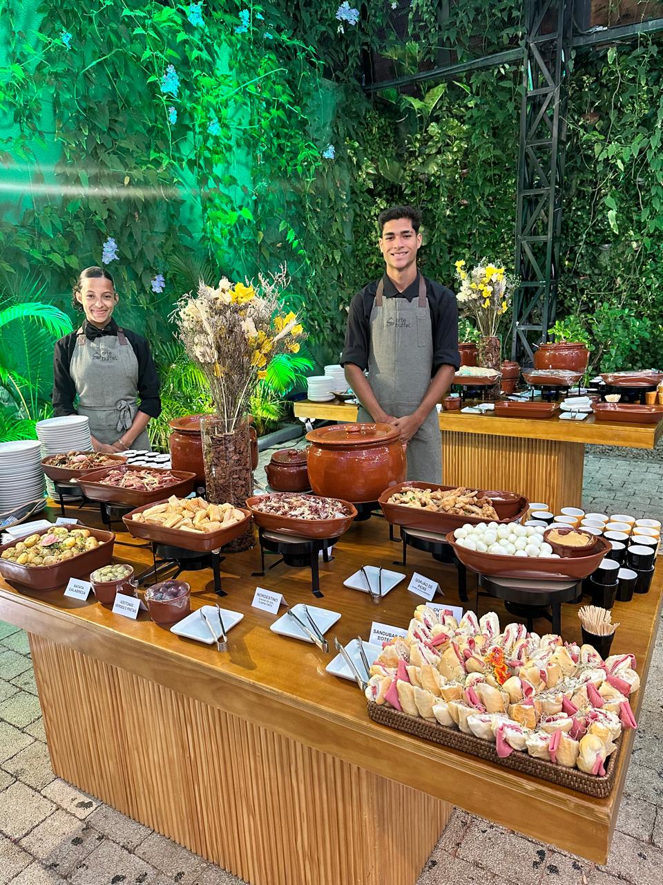 Buffet típico montado em panelas de barro com equipe servindo