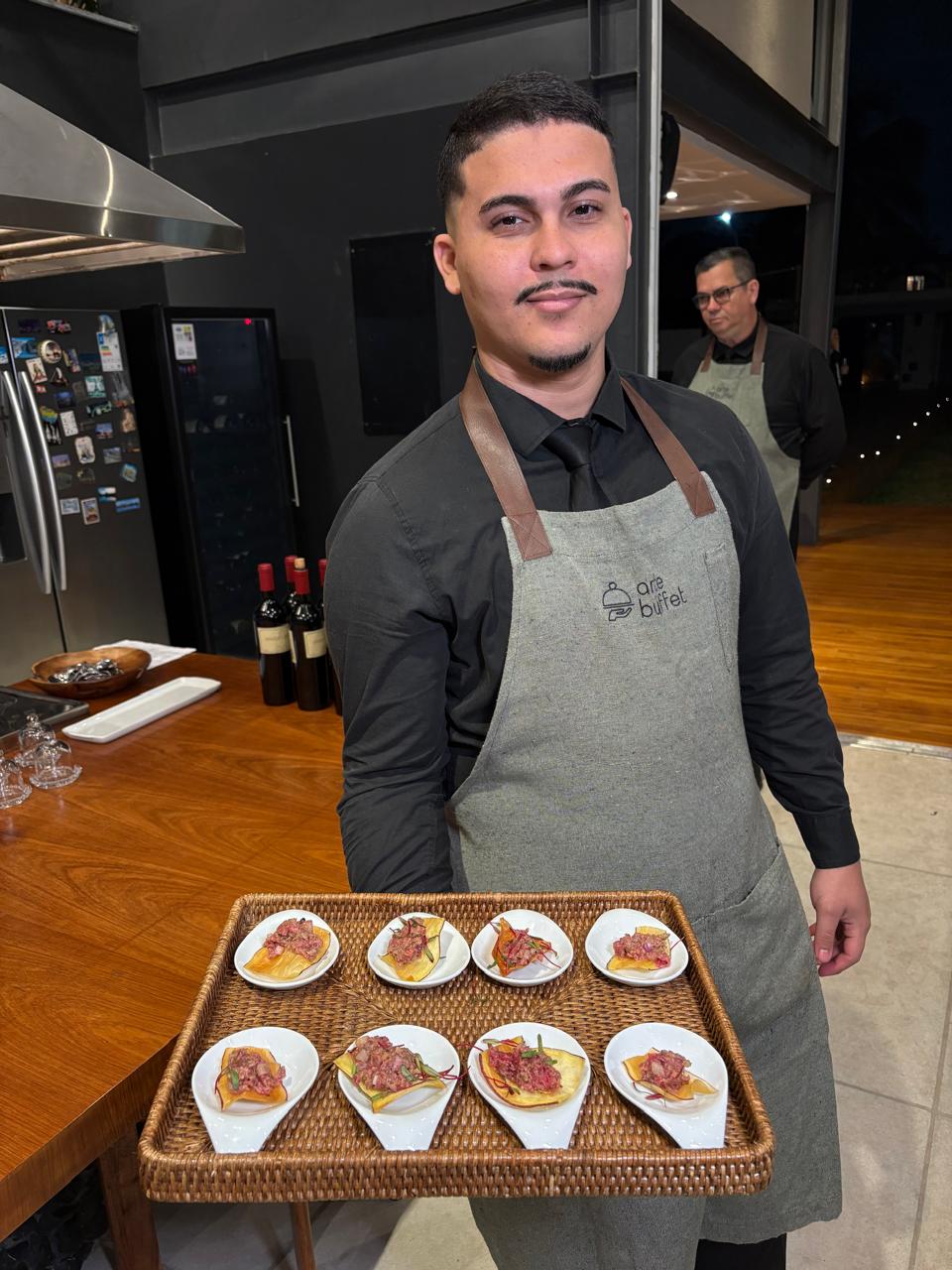 Garçom do Arte Buffet apresentando bandeja de canapés